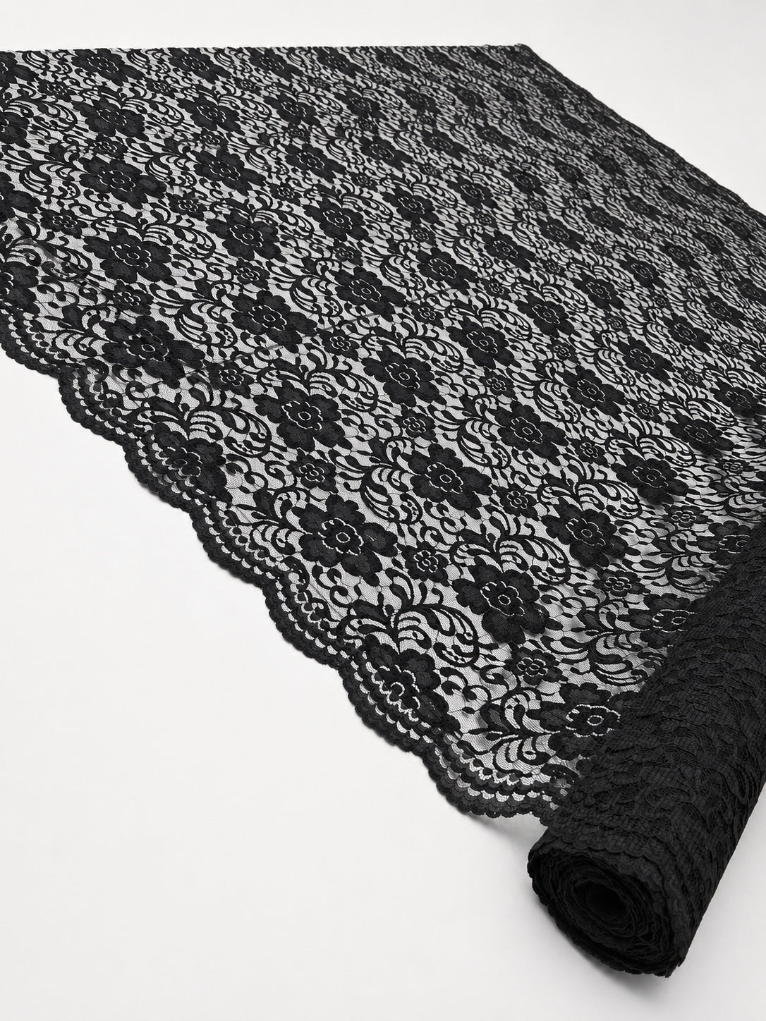 Black Indonesian non-stretch floral lace shown across the roll to display the pattern and scalloped border